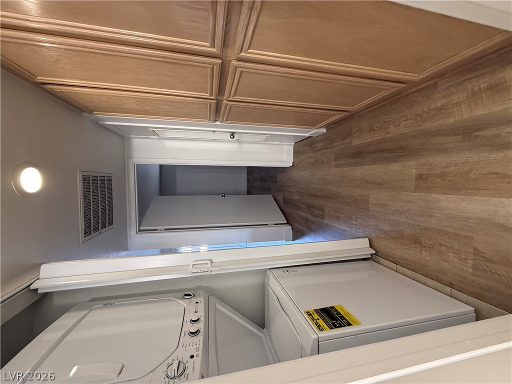 8070 West Russell Road, Unit 1092 Las Vegas, NV 89113 - Photo 10 of 14 Ample built-in cabinetry and durable wood-look flooring enhance this functional home laundry space.