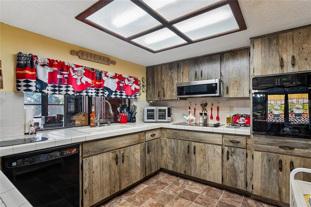 11122 Maderia Street Spring Hill, FL 34609 - Photo 13 of 49 a kitchen that has a sink cabinets and wooden floor
