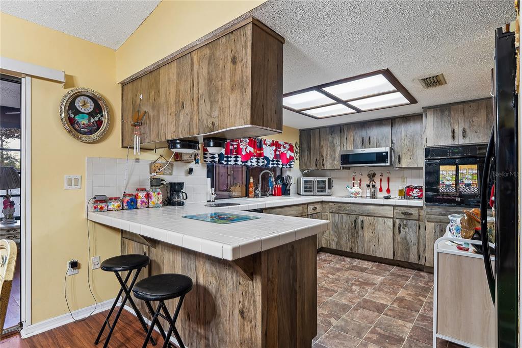 11122 Maderia Street Spring Hill, FL 34609 - Photo 14 of 49 a kitchen with a sink cabinets and wooden floor