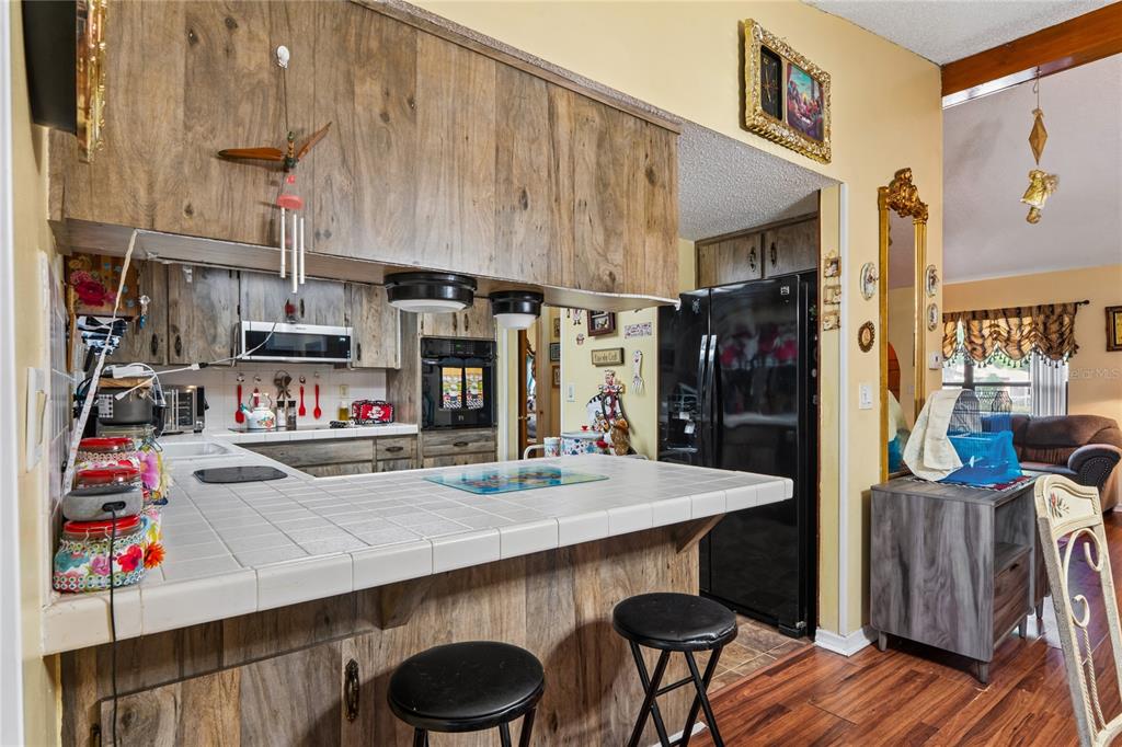 11122 Maderia Street Spring Hill, FL 34609 - Photo 15 of 49 a living room with stainless steel appliances kitchen island granite countertop furniture and a wooden floor