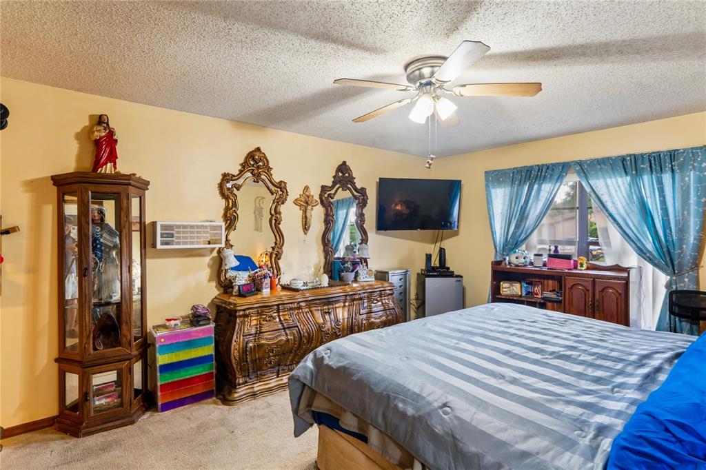 11122 Maderia Street Spring Hill, FL 34609 - Photo 19 of 49 a bedroom with a bed and a chandelier