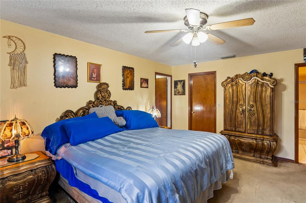 11122 Maderia Street Spring Hill, FL 34609 - Photo 21 of 49 a bedroom with a bed and a chandelier