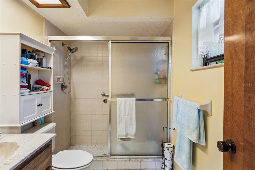 11122 Maderia Street Spring Hill, FL 34609 - Photo 23 of 49 a bathroom with a granite countertop shower sink vanity and toilet