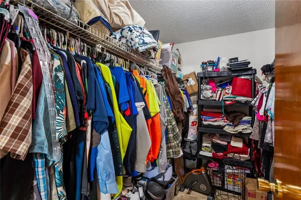 a view of walk in closet with clothes