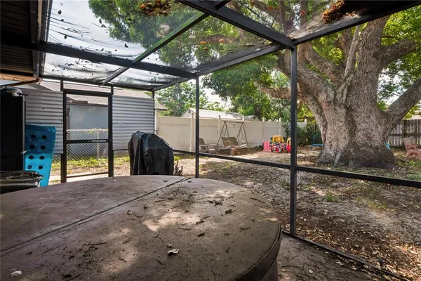 a view of a backyard with table and chairs and a large tree