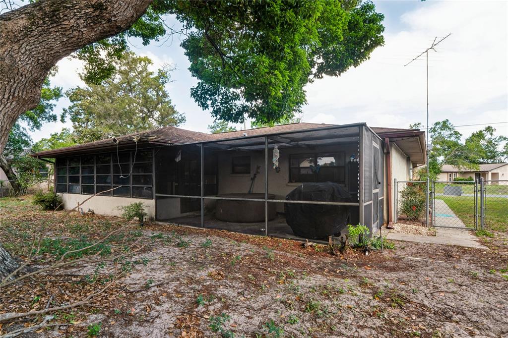 11122 Maderia Street Spring Hill, FL 34609 - Photo 37 of 49 a view of a house with a yard and a large tree