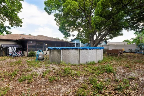 a view of a house with a yard and large tree