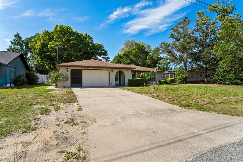 11122 Maderia Street Spring Hill, FL 34609 - Photo 41 of 49 a house with yard in front of it