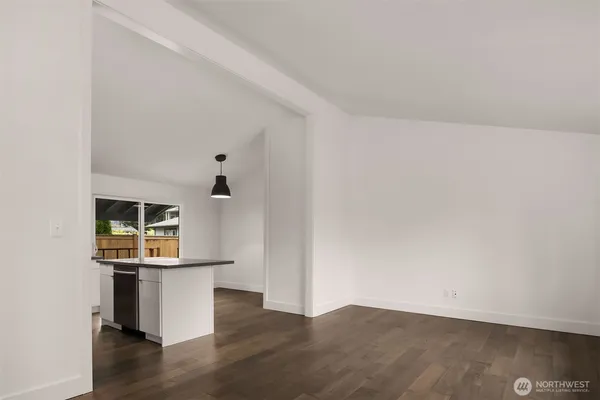 a view of a kitchen with wooden floor and a flat screen tv