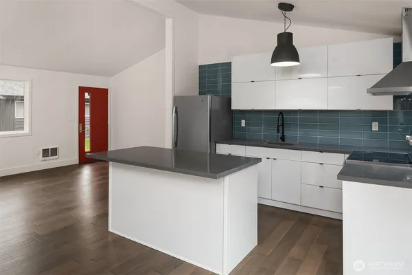 a kitchen with stainless steel appliances granite countertop a sink a stove and a wooden floors