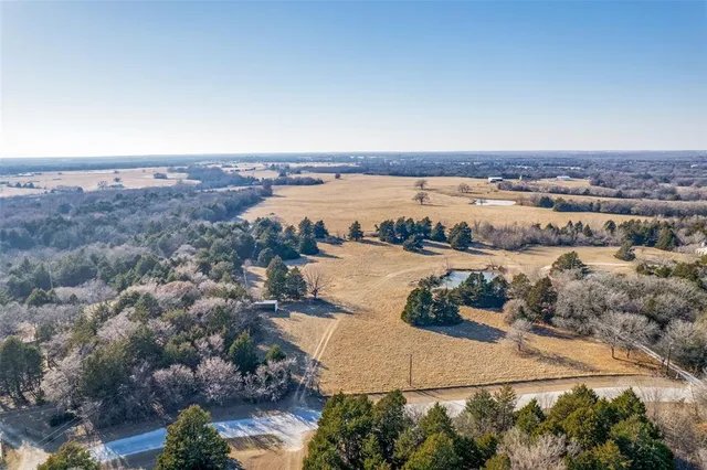 an aerial view of ocean and residential houses with outdoor space