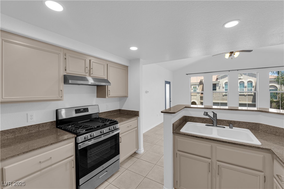 10550 West Alexander Road, Unit 2079 Las Vegas, NV 89129 - Photo 9 of 40 Kitchen with stainless steel gas range, under cabinet range hood, a sink, light tile patterned flooring, and recessed lighting