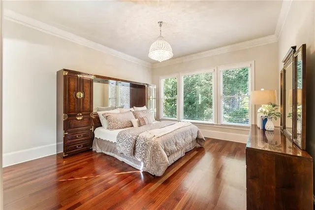 a bedroom with a bed wooden floor and window