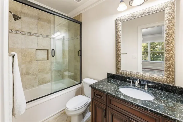 a bathroom with a granite countertop sink toilet a mirror and shower