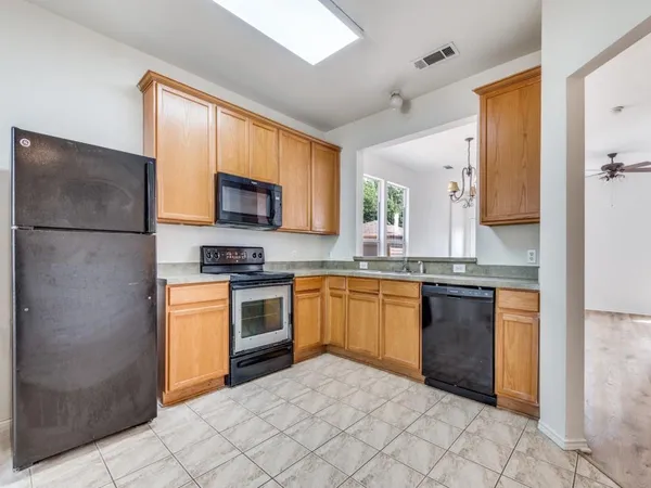 a kitchen with granite countertop a refrigerator and a stove top oven