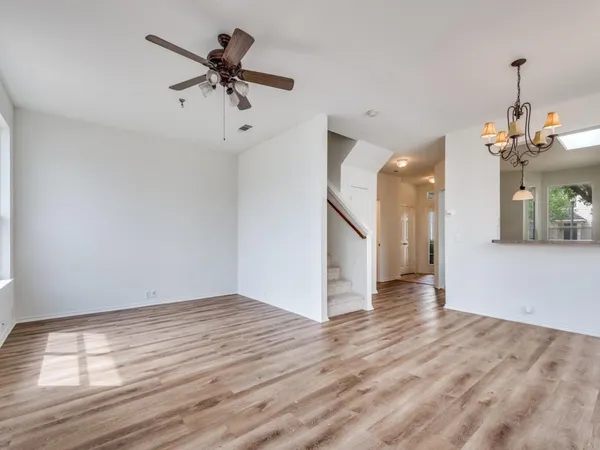 a view of empty room with wooden floor and ceiling fan