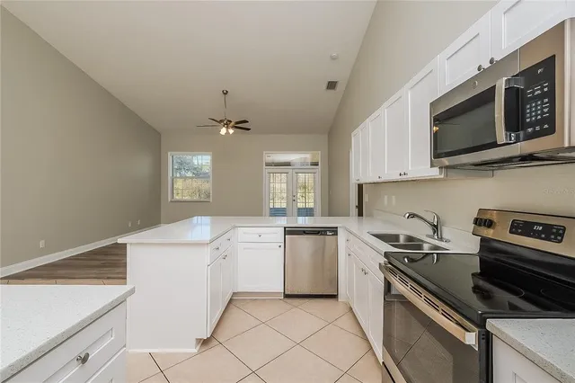 a kitchen with white cabinets appliances and sink