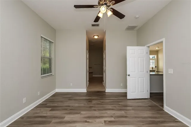 a view of an empty room with window and wooden floor