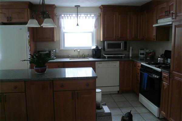23 Whittier Road Billerica, MA 01821 - Photo 8 of 25 a kitchen with a sink a microwave and cabinets