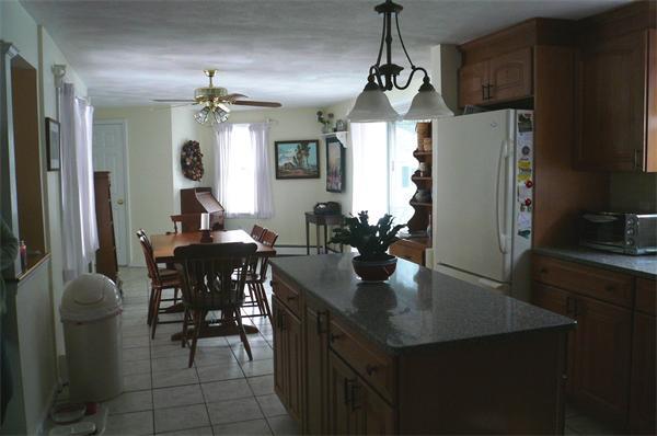 23 Whittier Road Billerica, MA 01821 - Photo 10 of 25 a kitchen with stainless steel appliances granite countertop sink refrigerator dining table and chairs