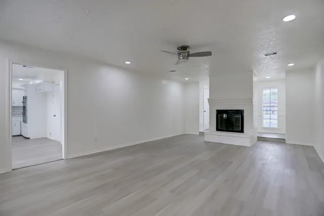 an empty room with wooden floor and fireplace