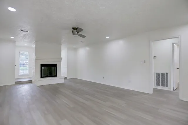 an empty room with wooden floor and fireplace