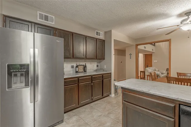 a kitchen with stainless steel appliances granite countertop a refrigerator and a sink