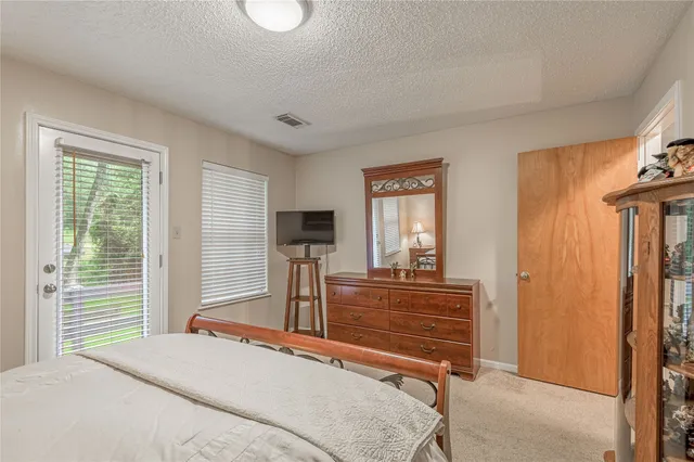 a bedroom with a bed and large windows