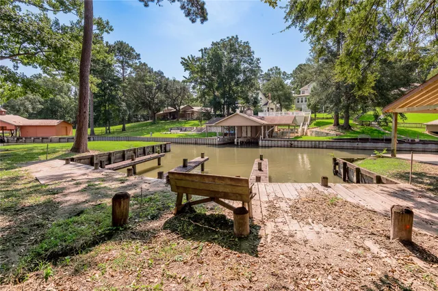 a view of a lake with a bench and trees around