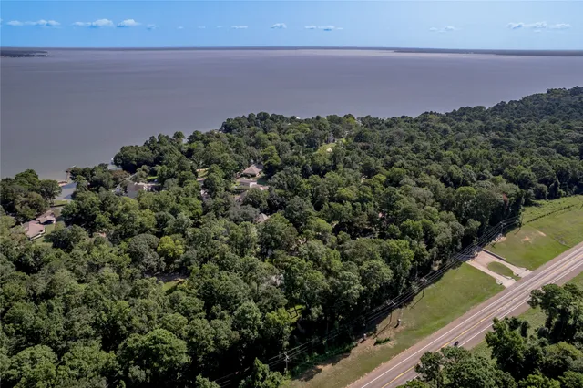 an aerial view of a houses with a yard and lake view