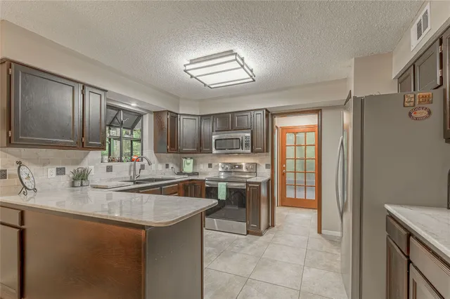 a kitchen with stainless steel appliances granite countertop a sink stove and refrigerator