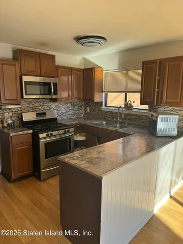 a kitchen with stainless steel appliances granite countertop a stove a sink and a microwave