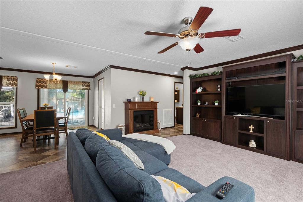 3283 Neff Lake Road Brooksville, FL 34602 - Photo 15 of 37 a living room with furniture a fireplace and a flat screen tv