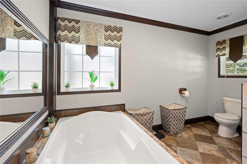 3283 Neff Lake Road Brooksville, FL 34602 - Photo 22 of 37 a bedroom with a bed and a window with chair