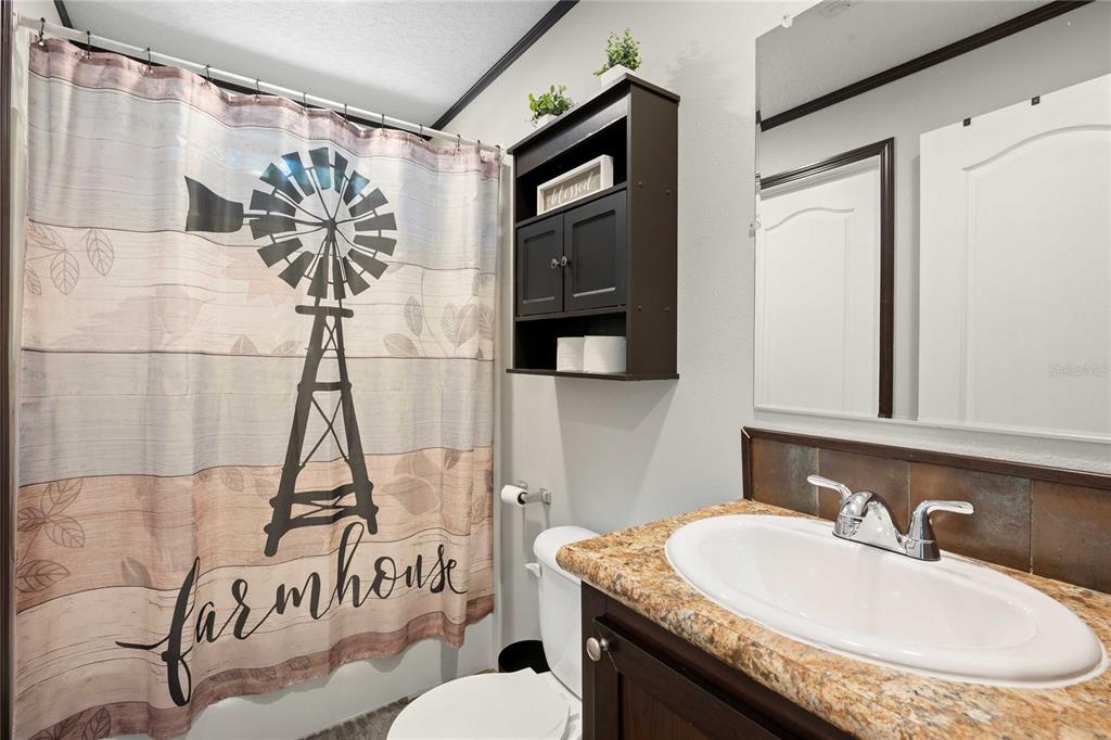 3283 Neff Lake Road Brooksville, FL 34602 - Photo 25 of 37 a bathroom with a granite countertop sink a mirror and a shower