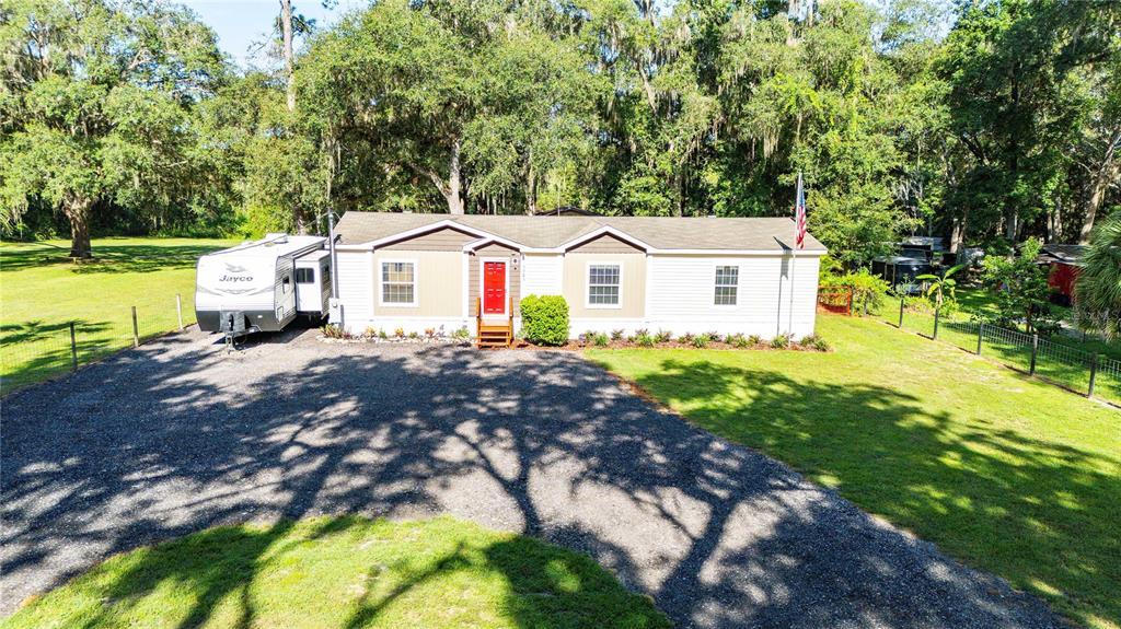 3283 Neff Lake Road Brooksville, FL 34602 - Photo 3 of 37 a front view of a house with a garden and trees