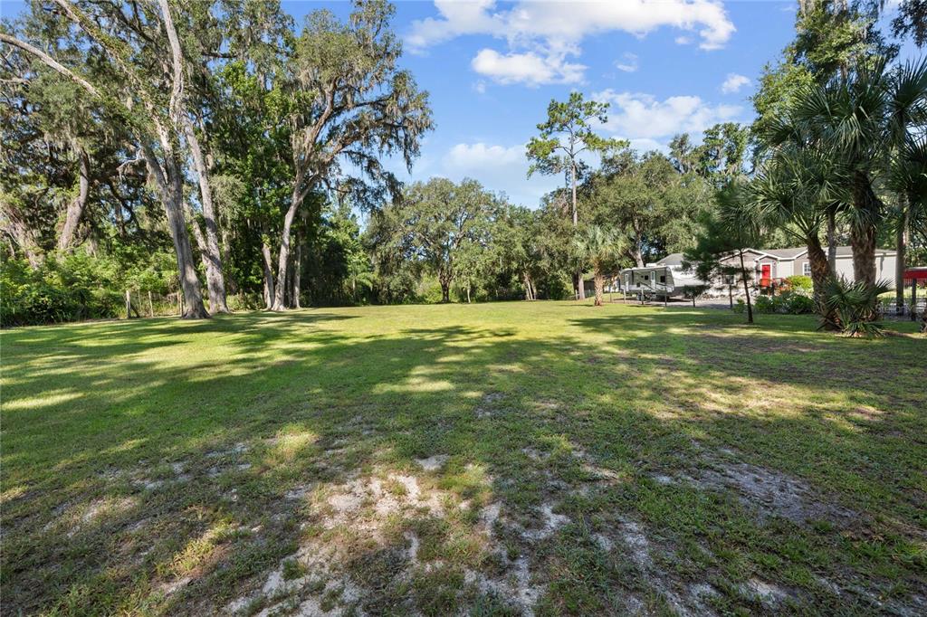 3283 Neff Lake Road Brooksville, FL 34602 - Photo 36 of 37 a backyard of a house with lots of green space and outdoor seating
