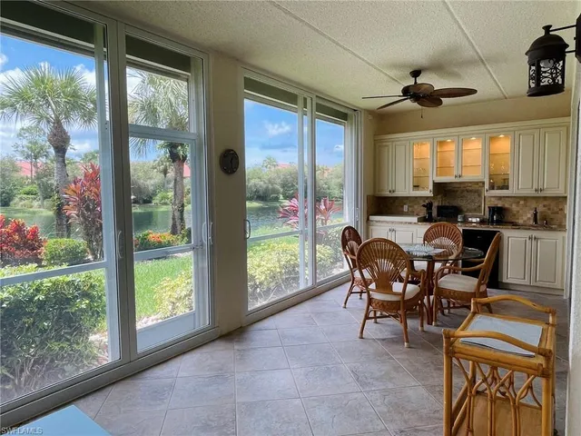 a dining room with furniture and a floor to ceiling window