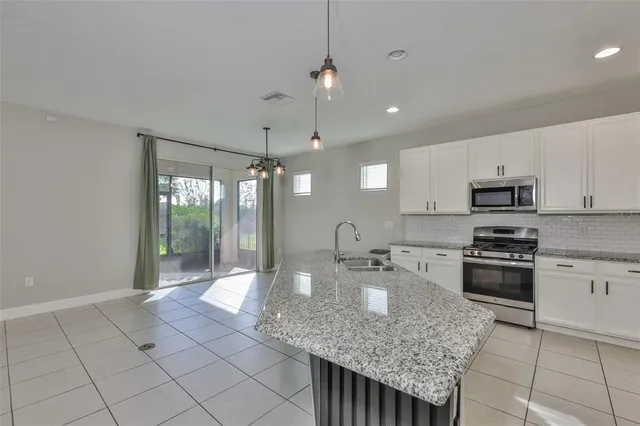 a kitchen with stainless steel appliances granite countertop a sink stove and cabinets
