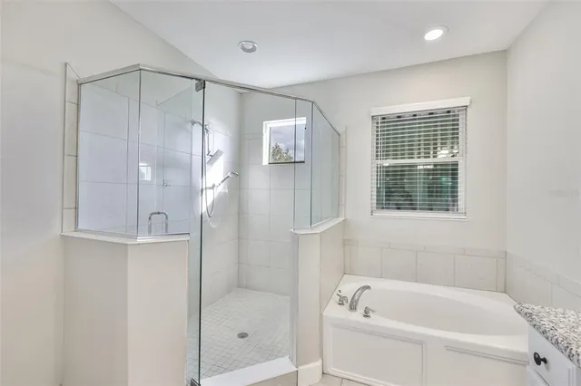a bathroom with a granite countertop double vanity sink and a mirror