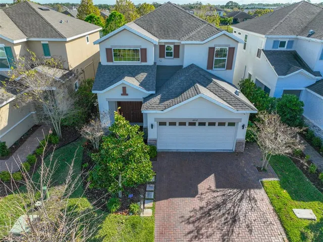 a view of a house with a yard and potted plants
