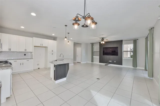 a large kitchen with stainless steel appliances granite countertop a stove a sink and a refrigerator