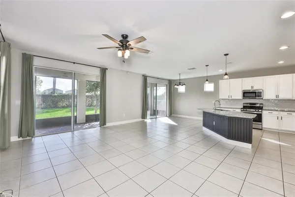 a view of an empty room and kitchen view