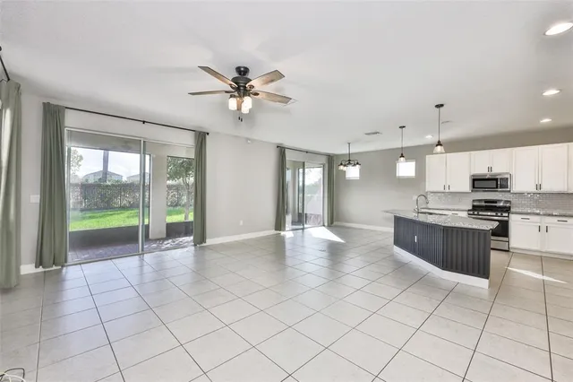 a view of an empty room and kitchen view