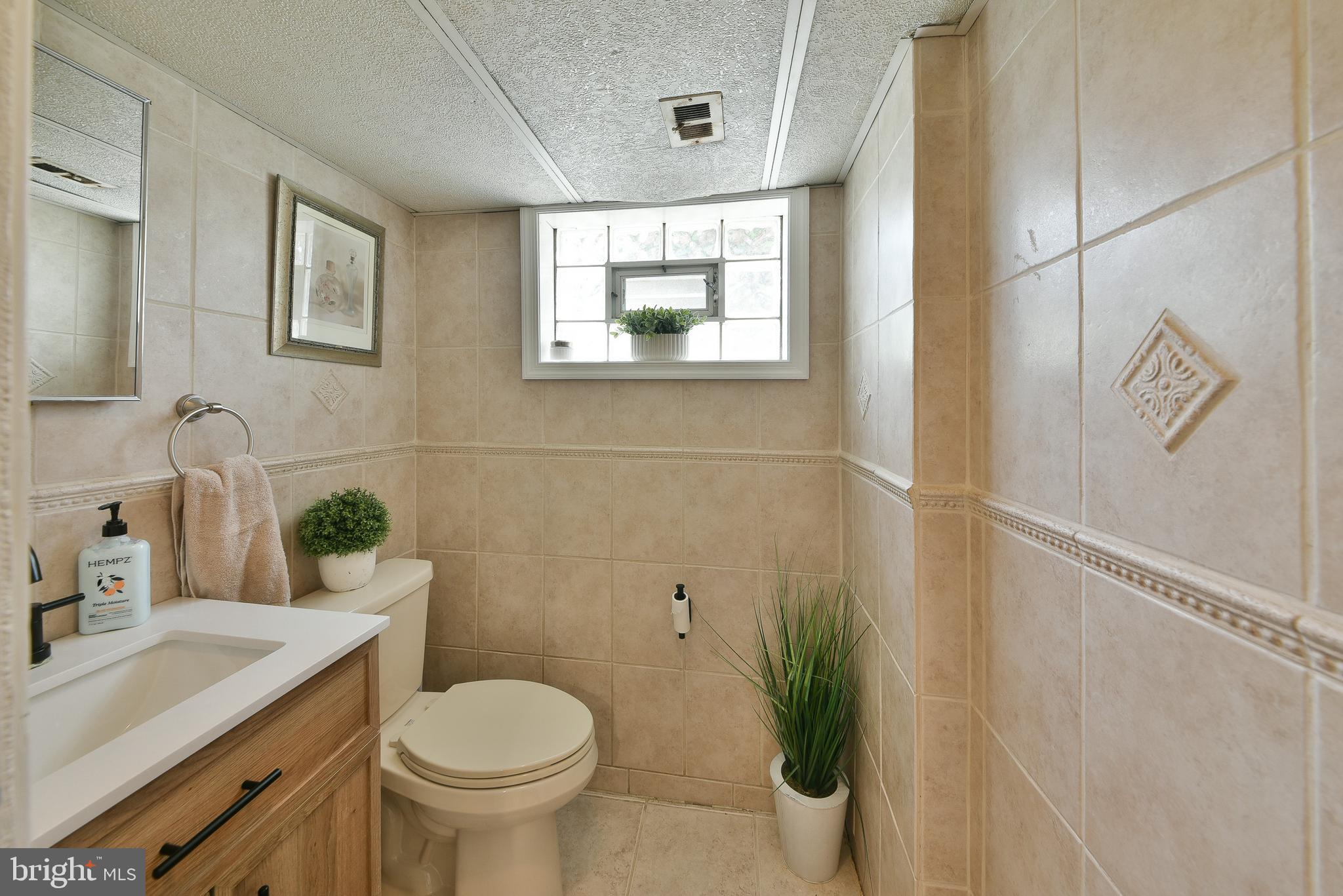 3137 Draper Street Philadelphia, PA 19136 - Photo 17 of 39 a bathroom with a granite countertop toilet a sink and a mirror