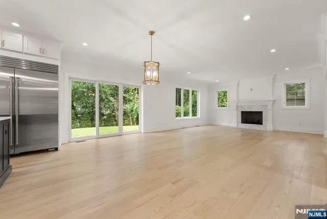 a view of an empty room with a fireplace and a window