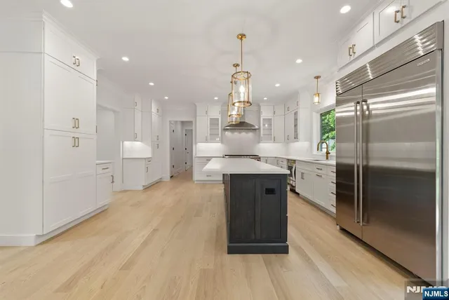 a open kitchen with kitchen island a sink stainless steel appliances and cabinets