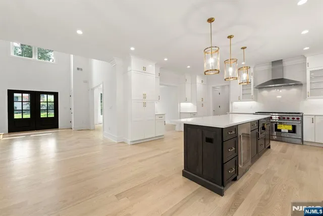 a large kitchen with a lot of counter space and wooden floor