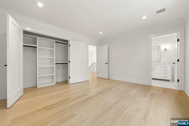 a view of an empty room with closet and entryway