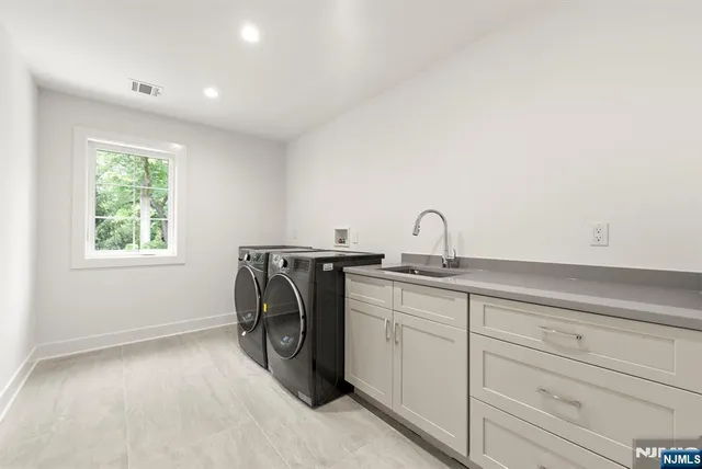 a utility room with sink dryer and washer